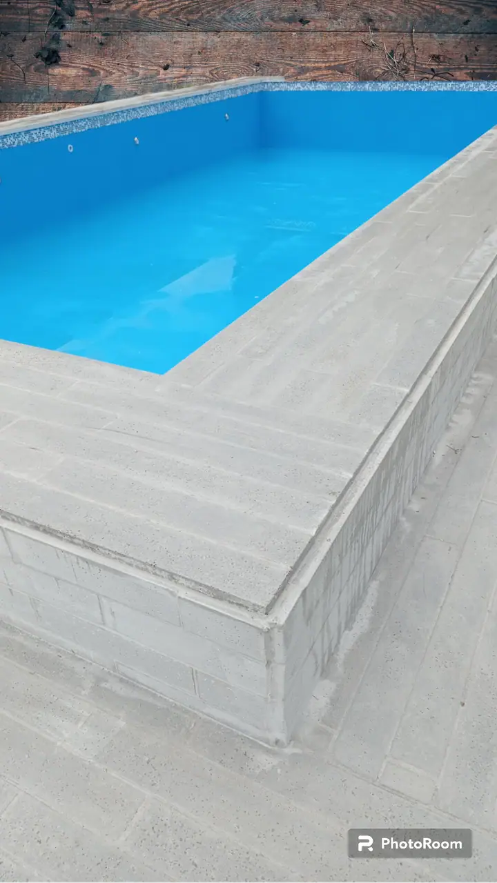 Detalle de esquina de borde atérmico gris sobre la piscina