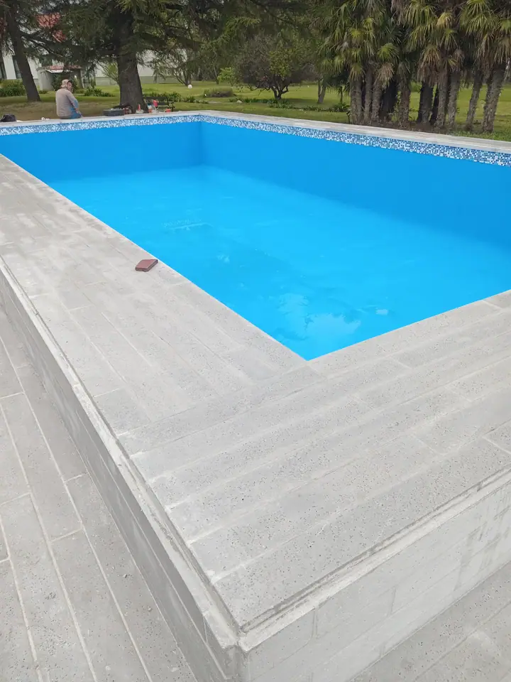 Deck atérmico de placas símil madera rodeando una piscina