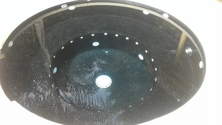 Interior de jacuzzi circular revestido en venecita negra con hidrojets