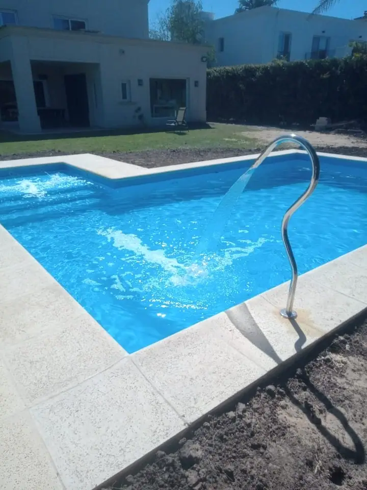 Piscina con baranda de acero inoxidable y borde claro