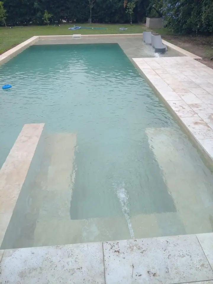 Piscina de agua clara con escalones de ingreso y borde claro