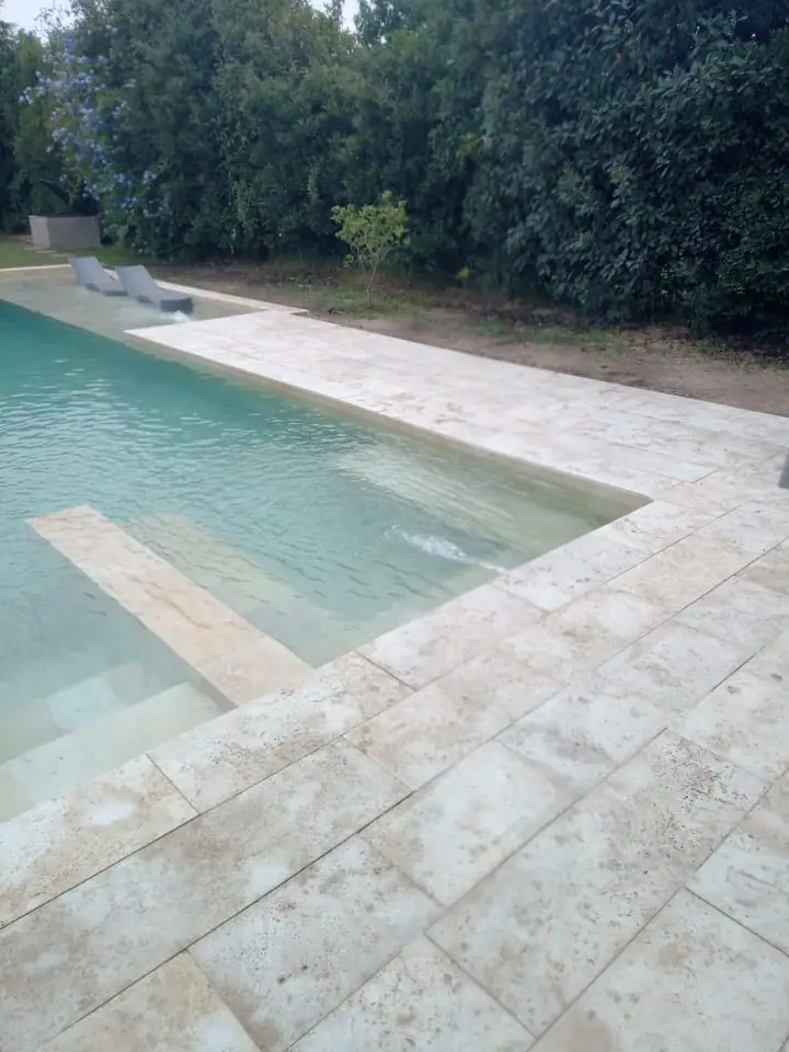 Piscina con solárium de placas claras y escalones de ingreso