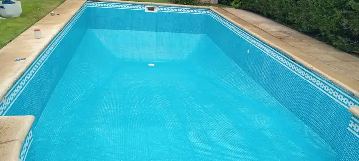 Interior de piscina en venecita celeste con guarda decorativa en el borde