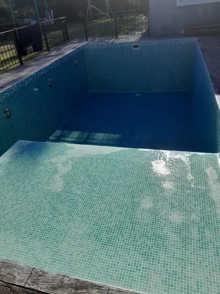 Piscina revestida en venecita verde agua con escalón de ingreso